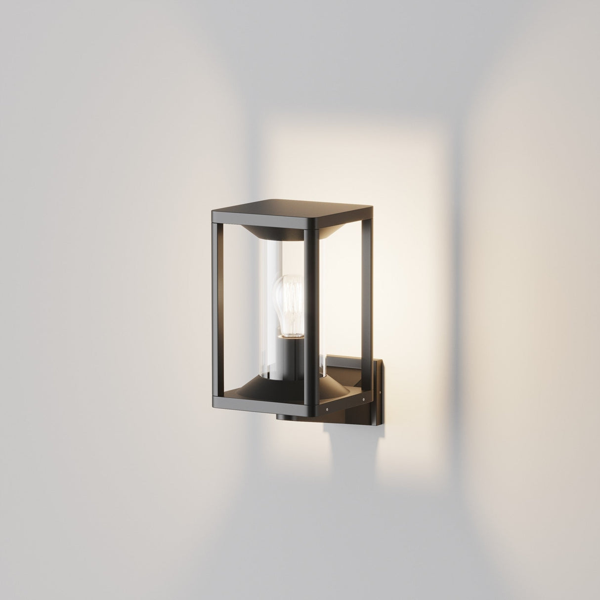 The Cell Outdoor Up Wall Light in graphite boasts a wall-mounted, black lantern design with a visible bulb housed in a transparent enclosure. Its modern, minimalist look and IP65 rating deliver both style and durability.