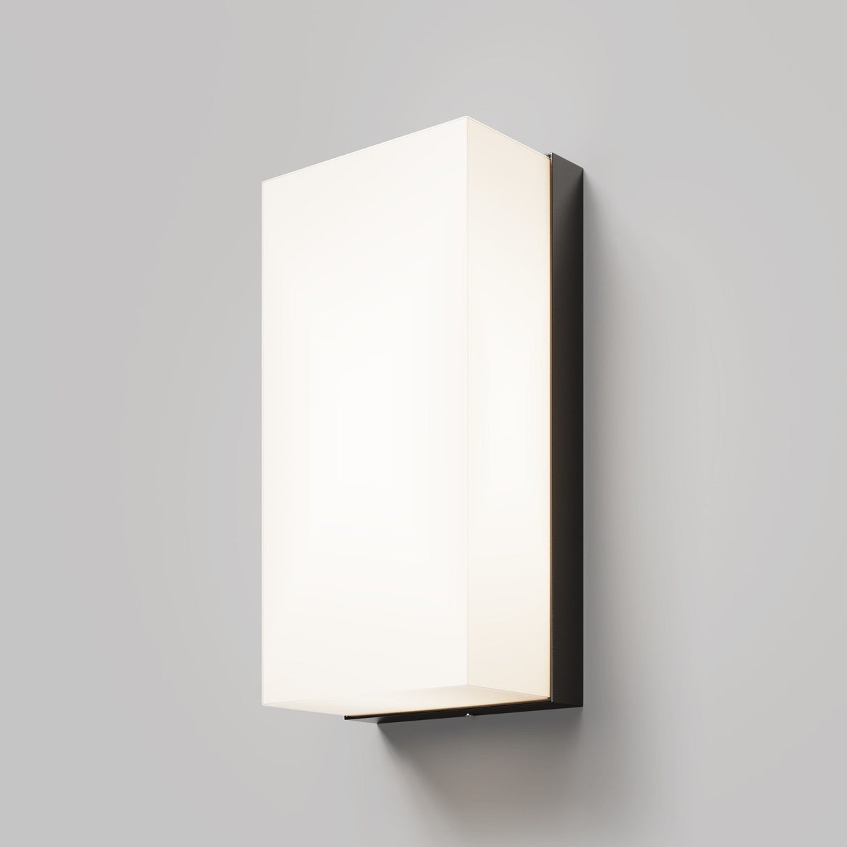 The Badd Outdoor Square Wall Light 3000K - Graphite features a modern rectangular white frosted shade and a dark graphite-finished base, casting soft, even light on a light gray wall.