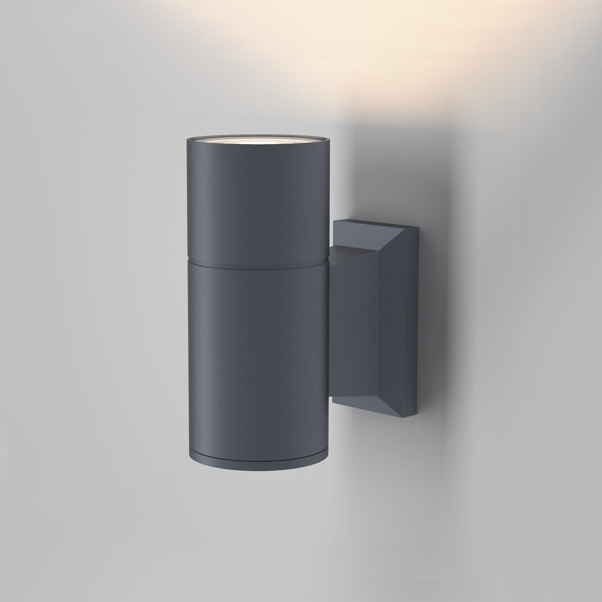 The Bowery Outdoor 1 Light Wall Light - Grey (O574WL-01GR) features a sleek cylindrical design with a rectangular mounting base. Its durable construction provides a soft upward glow, enhancing any contemporary interior.