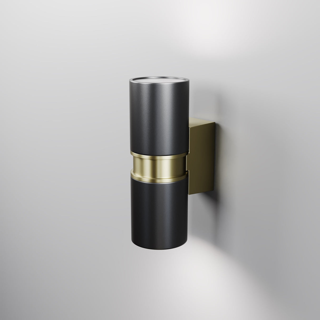 The Bowery Outdoor 2 Light Wall Light - Black (O582WL-02B) with brass accents and a sleek cylindrical design enhances a light gray wall. Its modern black and gold look, with upward and downward lighting, offers a soft glow. Ideal as an outdoor fixture with its durable IP54 rating.