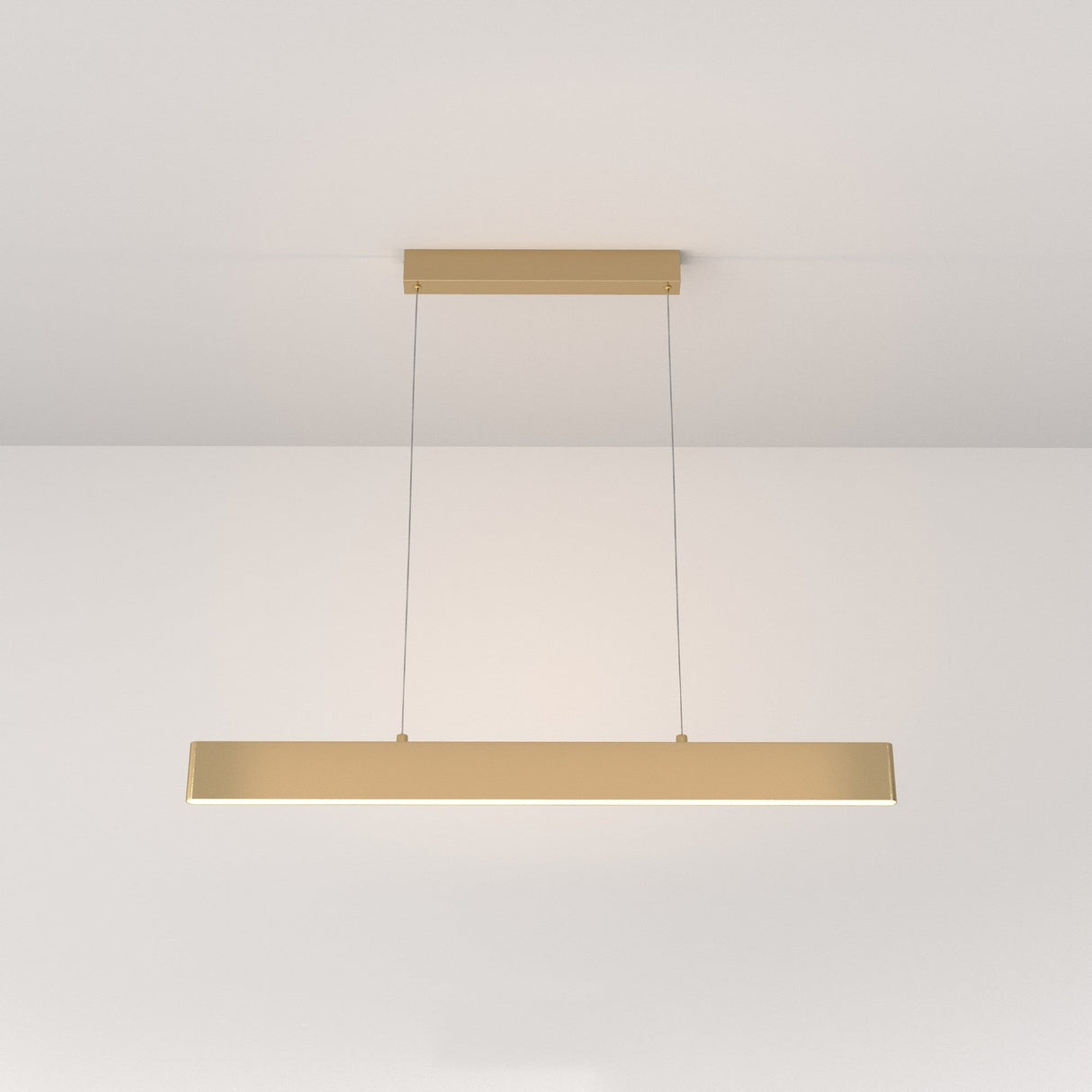 The Step LED Linear Suspension Light 3000K 23W - Gold features a minimalist rectangular design, suspended by two thin wires. Its efficient, modern look is highlighted against a plain white background.