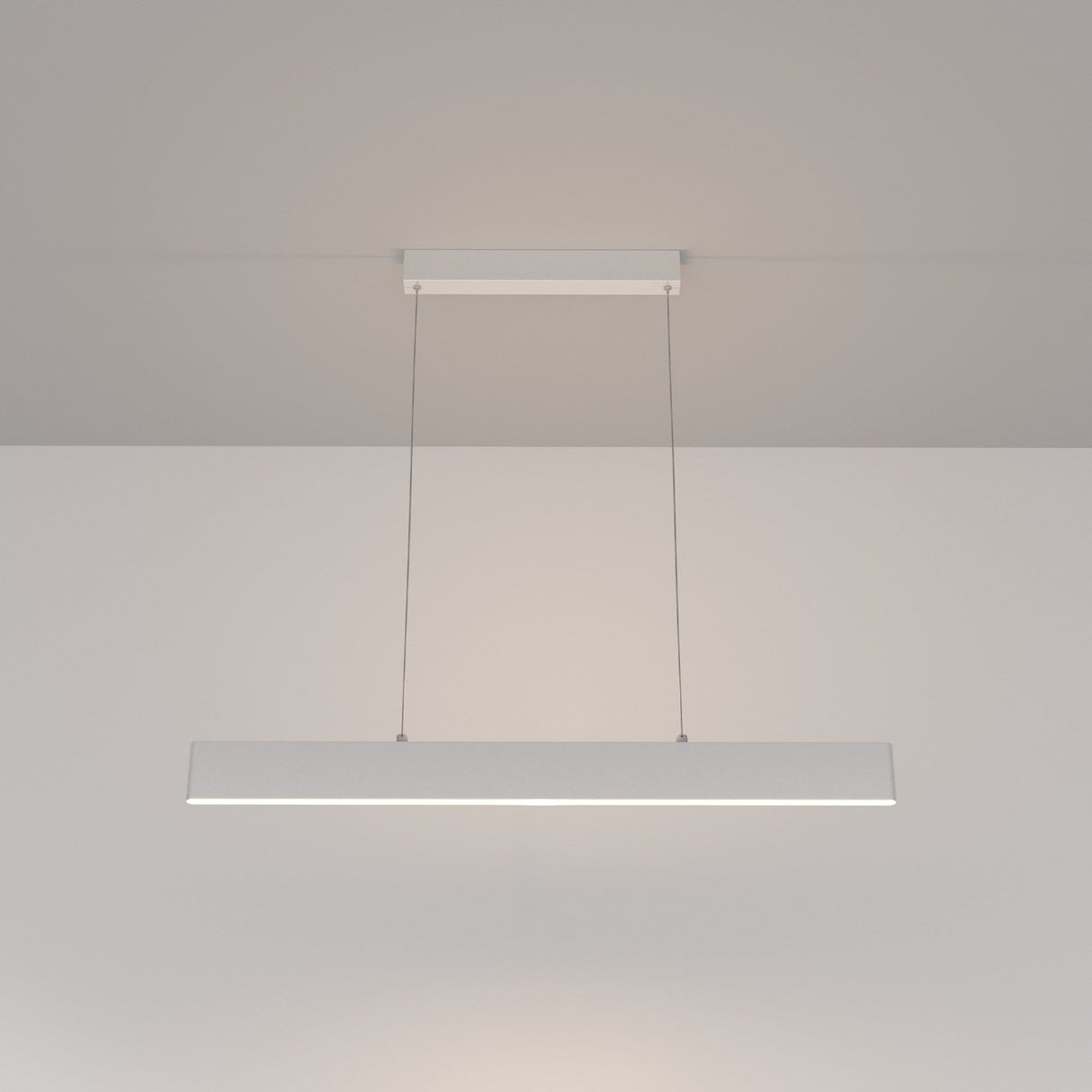 The Step LED Linear Suspension Light 3000K 23W - White showcases a minimalist pendant design, gracefully hung by two thin cables, with a sleek rectangular form that enhances any neutral-toned room with modern sophistication.