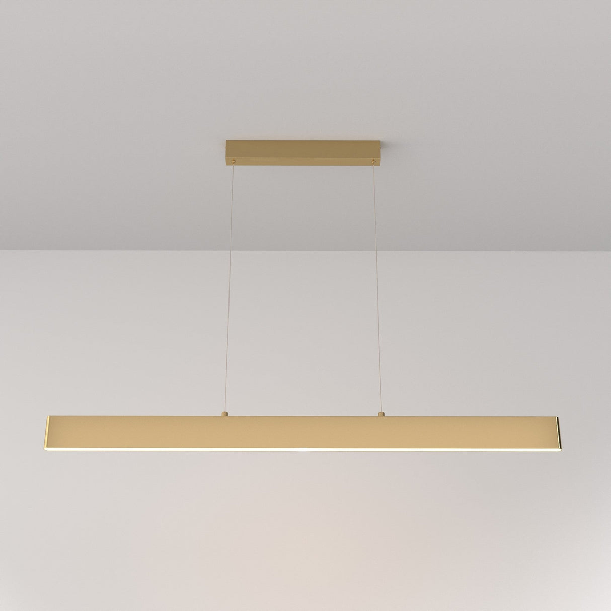 The Step LED Long Linear Suspension Light 3000K 30W - Gold features a sleek rectangular design, hangs from a white ceiling by two thin wires with SMD LEDs, and creates an elegant, minimalist ambiance.