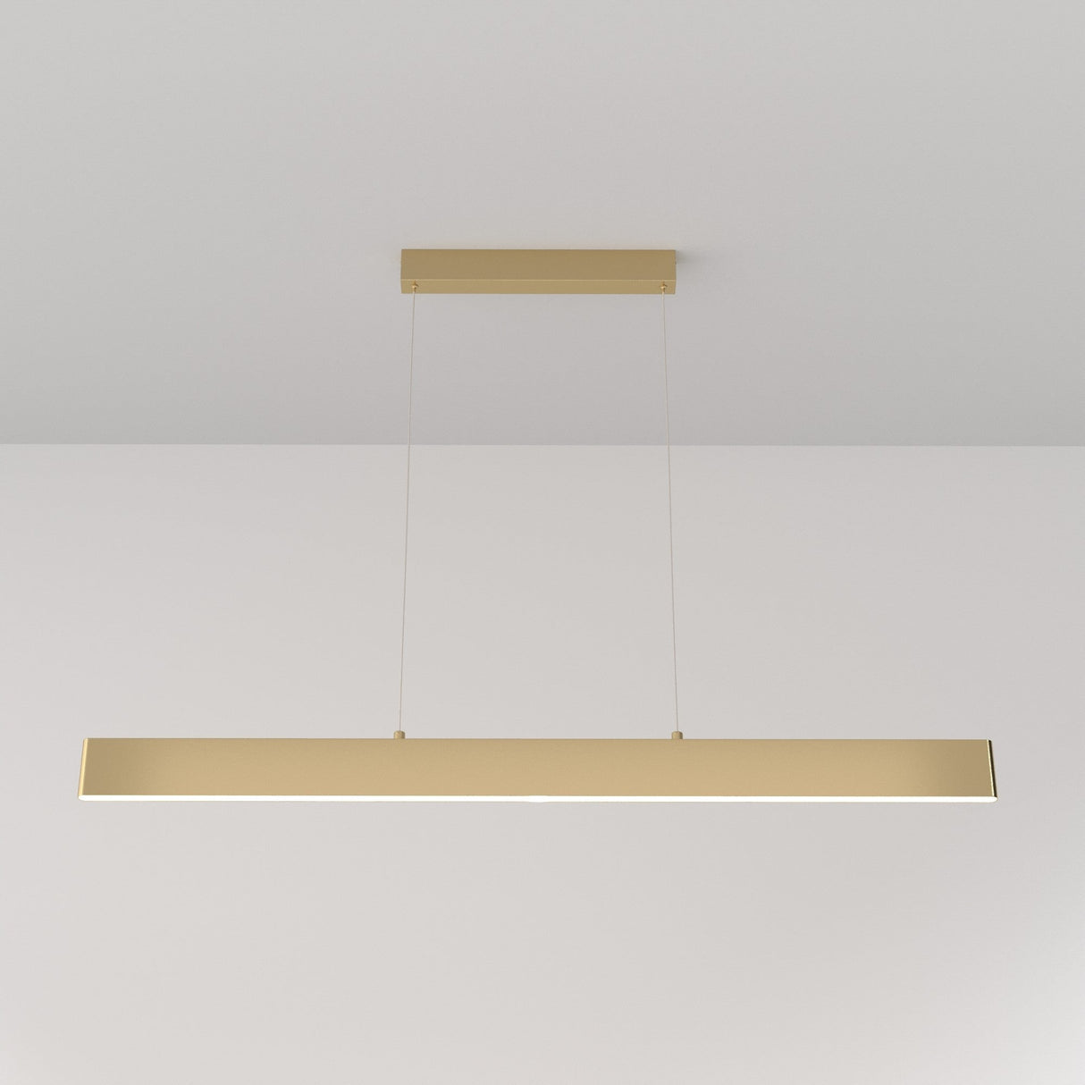 The Step LED Long Linear Suspension Light 4000K 30W - Gold is a minimalist rectangular pendant with a luxurious gold finish, stylishly suspended by two thin cables against a plain white background.