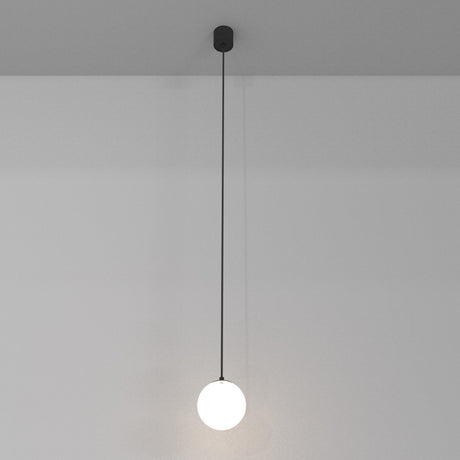 The Luna LED Globe Pendant Light 10cm 4000K - Black & White features a glowing white sphere that complements modern interiors. Suspended from a black cord against a gray ceiling, it offers energy-efficient lighting, enhancing simplicity and elegance against its plain white backdrop.