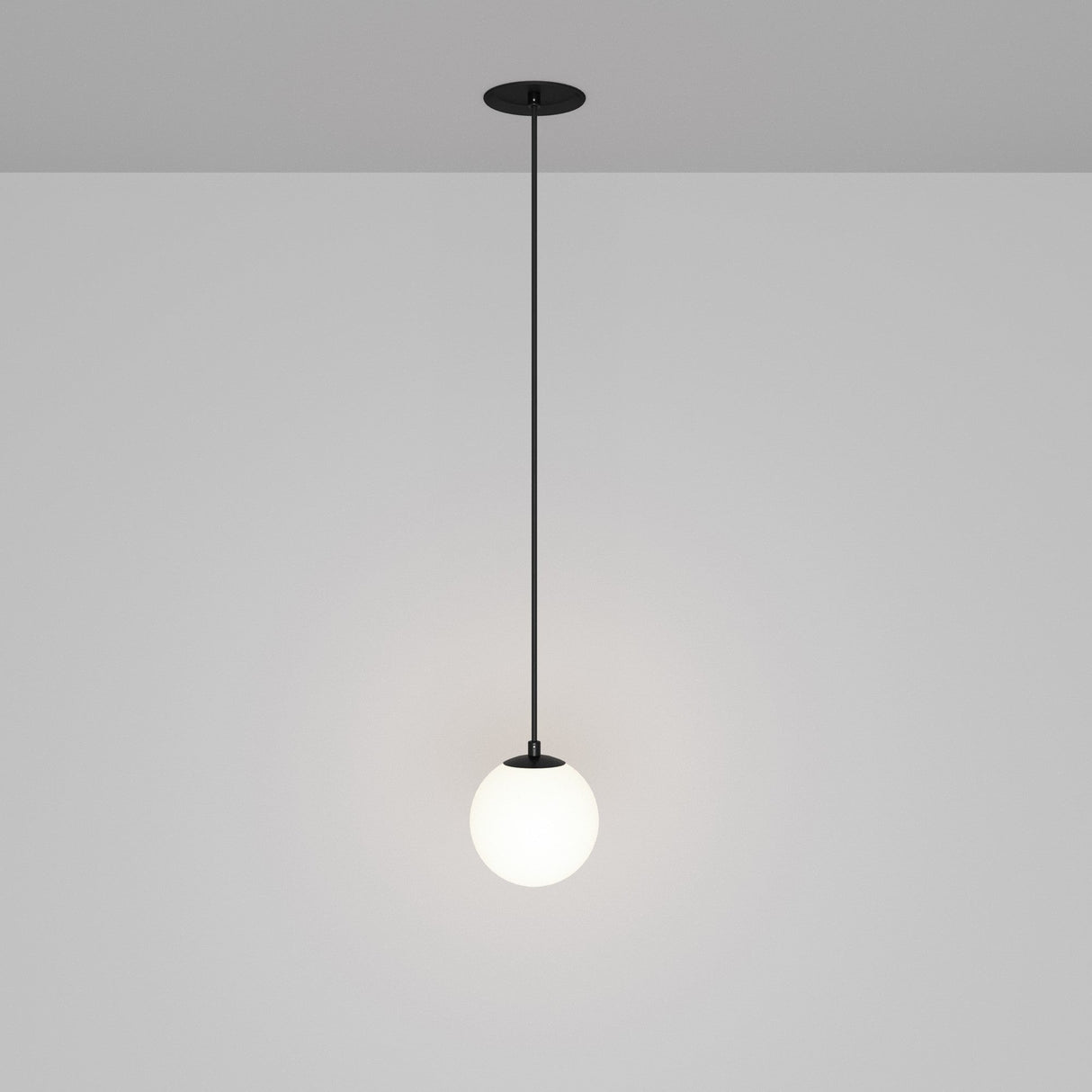 The Luna LED Recessed Globe Pendant Light 10cm 4000K - Black & White features a minimalist design with a black rod and white globe, casting an energy-efficient soft glow against a gray background that embodies contemporary style.