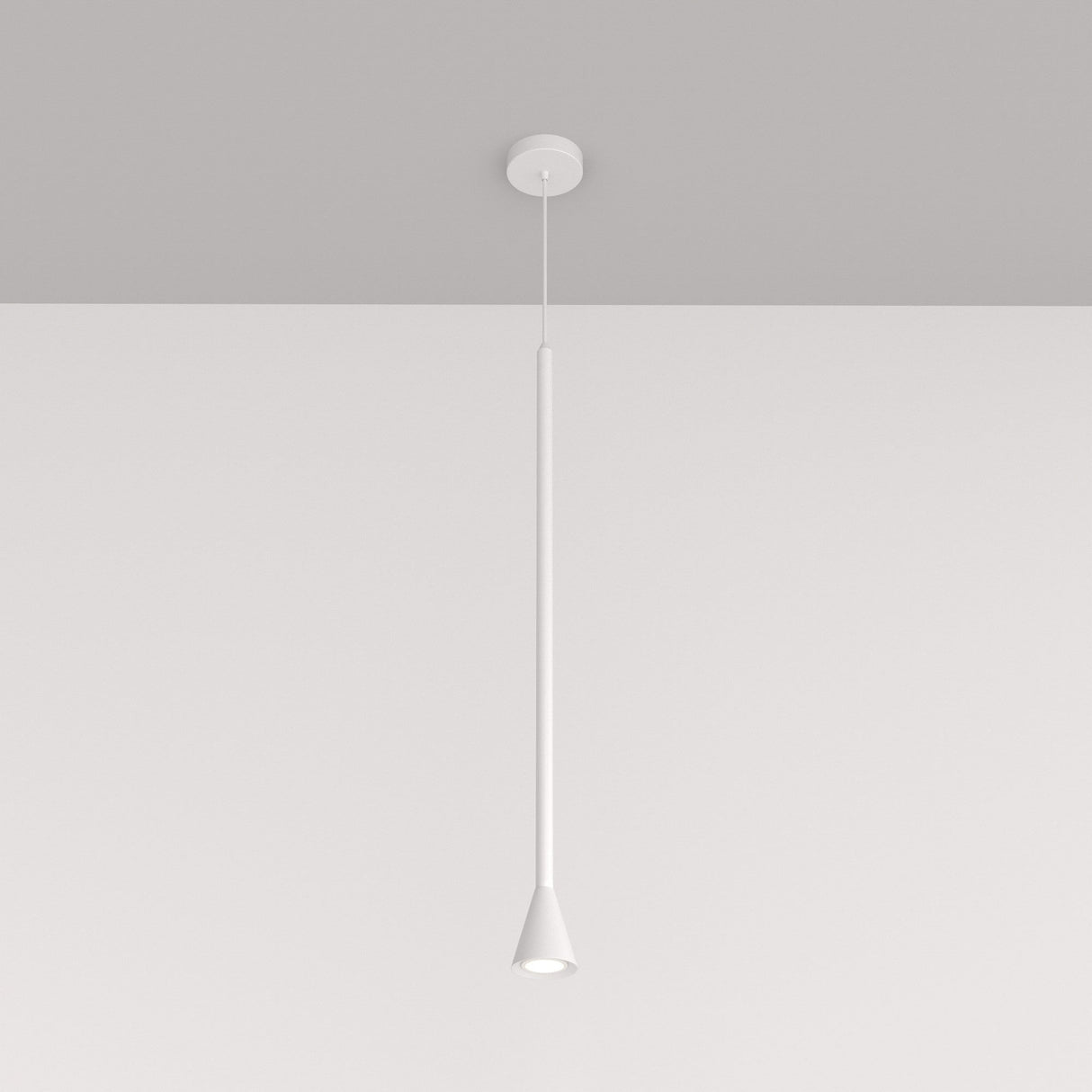 The Arrow 1 Light Long Cone Pendant - White, with its minimalist design, showcases a slender stem and cone-shaped shade. It elegantly suspends from a white ceiling on a light gray background, enhancing modern interiors.