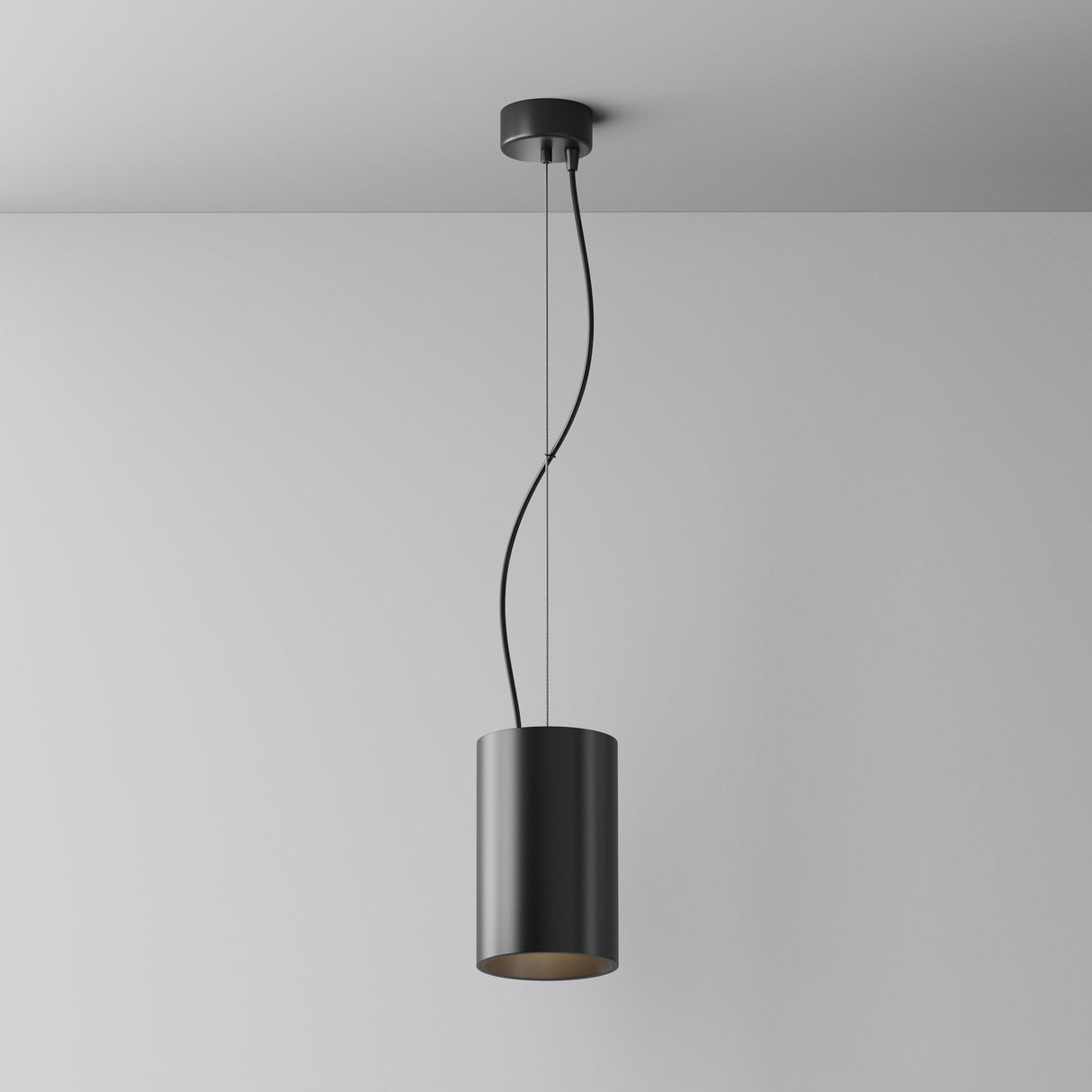 The Efir LED Pendant Light 33W - Black showcases a modern look with a sleek cylindrical black shade on a minimalist fixture. Its curved cord enhances plain white ceilings and walls, while the energy-efficient LED design combines style with sustainability.