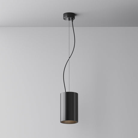 The Efir LED Pendant Light 33W - Black showcases a modern look with a sleek cylindrical black shade on a minimalist fixture. Its curved cord enhances plain white ceilings and walls, while the energy-efficient LED design combines style with sustainability.