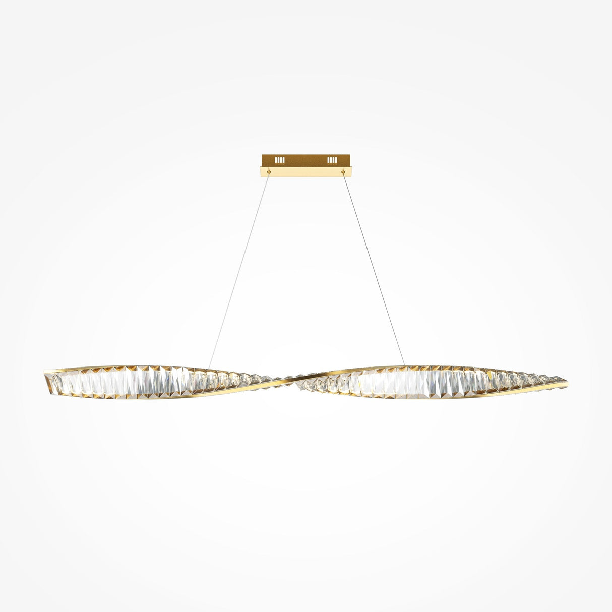 The Krone LED Long Crystal Linear Suspension Light - Brass showcases a modern design with two intertwined, elongated brass loops and translucent materials. It hangs from thin wires connected to a rectangular gold ceiling mount, set against a plain white background.