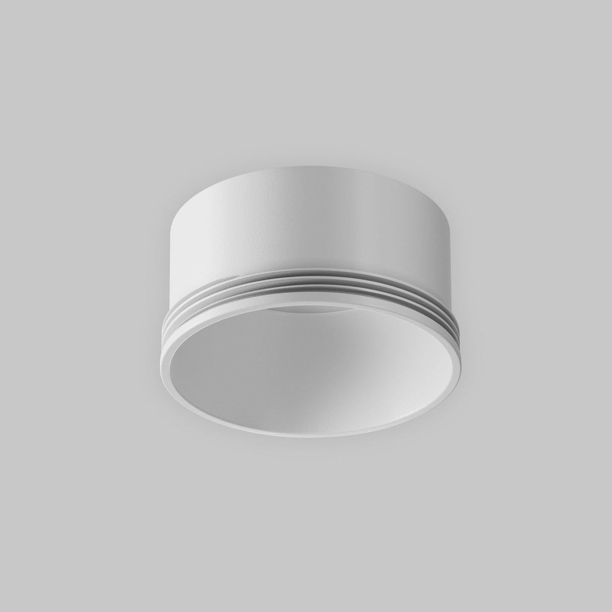 The Focus LED Small Decorative Ring for Track Spotlight - White features a minimalist cylindrical design with a smooth finish, ideal for modern interiors, set against a plain gray background.