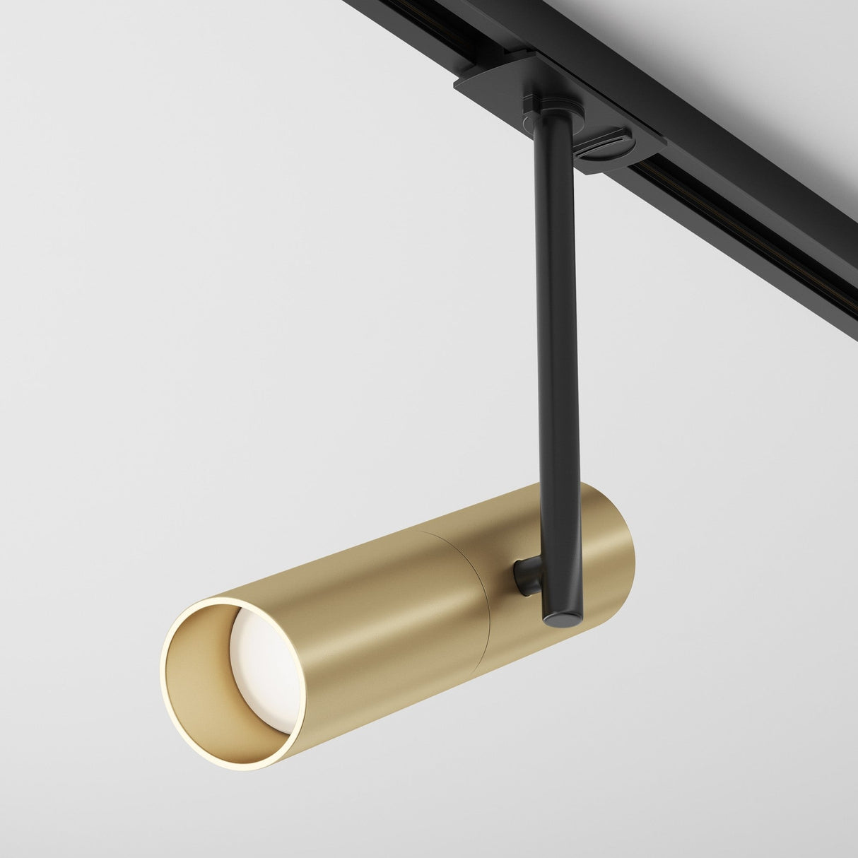 The Elti Single Phase Unity Track Spotlight in black and gold is a modern, cylindrical light with a sleek design and black mounting arm, ideal for accent lighting on neutral white ceilings.
