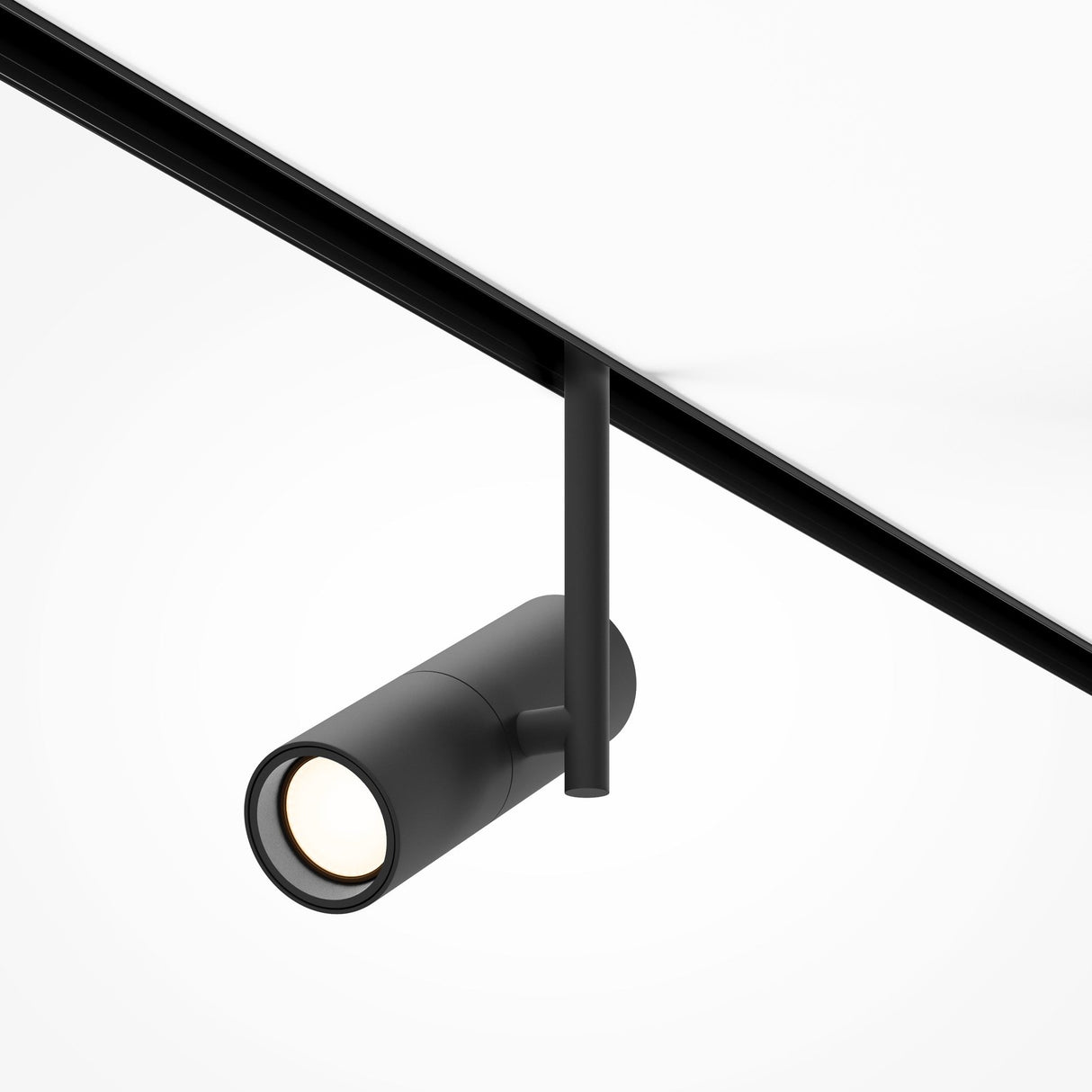 The Elti LED Magnetic Exility Track Spotlight 12W 3000K, in sleek black, hangs from a white ceiling on a matching track. This energy-efficient light offers a minimalist, modern design that directs illumination downward against the plain background.