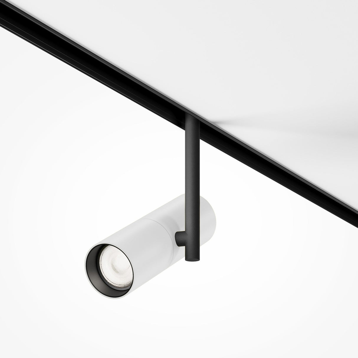 The Elti CCT Dimmable 12W LED Magnetic Exility Track Spotlight in black and white is mounted on a white ceiling. With its cylindrical design, its perfect for modern interiors, offering adjustable color temperature (2700-6000K) for versatile ambiance control and focused lighting.