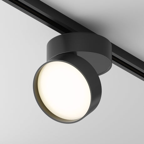 The Onda LED Single Phase Unity Track Spotlight 18W 3000K in black features a modern matte finish, adjustable head, and casts a soft glow on the smooth, light-colored ceiling.
