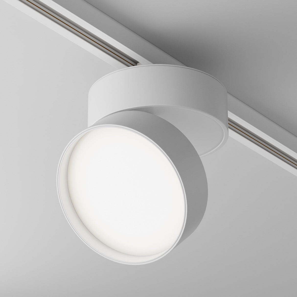 Close-up of the Onda LED Single Phase Unity Track Spotlight in white, featuring an adjustable head and sleek circular design. The 18W light emits a soft 4000K glow along the ceiling-mounted linear track.