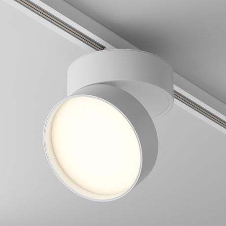The Onda LED Single Phase Unity Track Spotlight, 18W, 3000K in White is a modern round ceiling light with an adjustable track system. Its luminous circular LED bulb emits a soft warm white light, and it features a simple minimalist design.