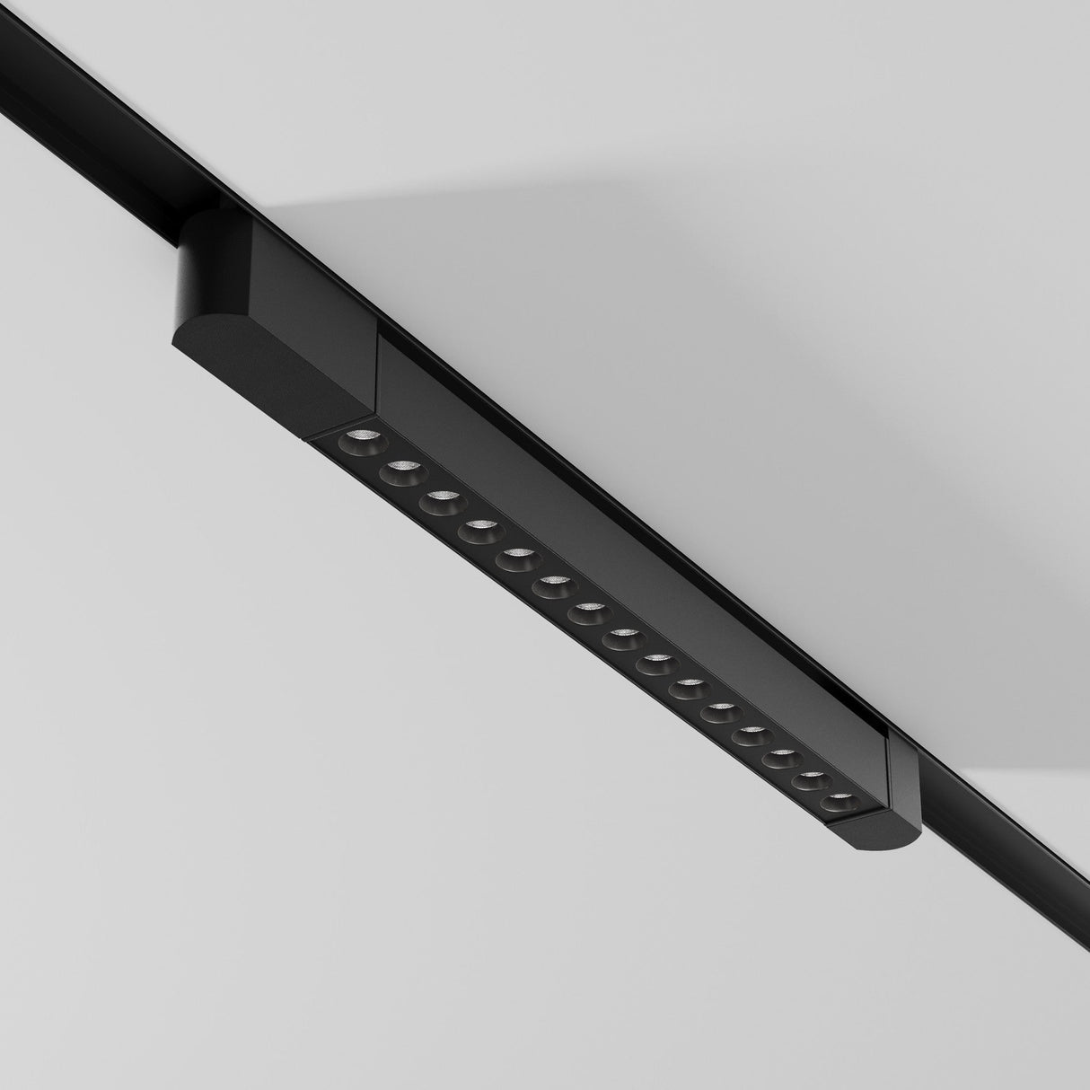 The Points Rot LED Swivel Linear Track Light, black and minimalist with 4000K cool white lights, mounts on a white ceiling. This 22W fixture for single-phase tracks has high CRI, offering a vibrant and contemporary look with its evenly spaced and adjustable design.