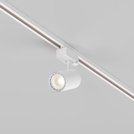 The Vuoro S 3-Circuit Trinity Track LED Spotlight 10W 3000K in white is mounted on a ceiling rail, providing focused downward lighting with its modern cylindrical design against a neutral background.