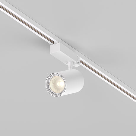 The Vuoro S 3-Circuit Trinity Track LED Spotlight is a modern white fixture with a cylindrical design and visible bulb, mounted on the ceiling and attached to a three-phase track. It stands out against a light gray background, offering 20W of 3000K illumination.