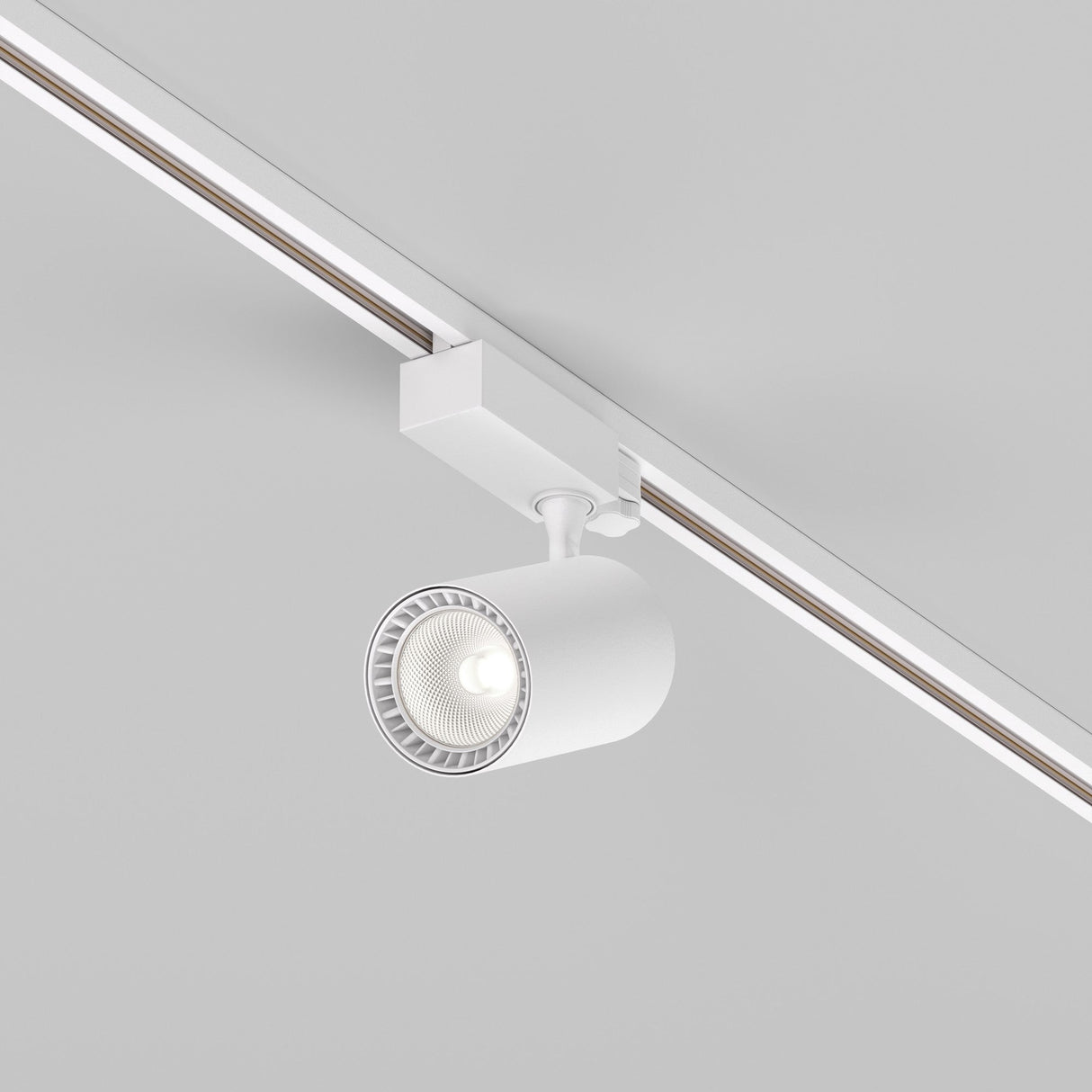 The Vuoro S 3-Circuit Trinity Track LED Spotlight, 20W in 4000K white, is mounted on a sleek, white cylindrical track against a plain ceiling. This setup delivers an energy-efficient and modern minimalistic aesthetic.