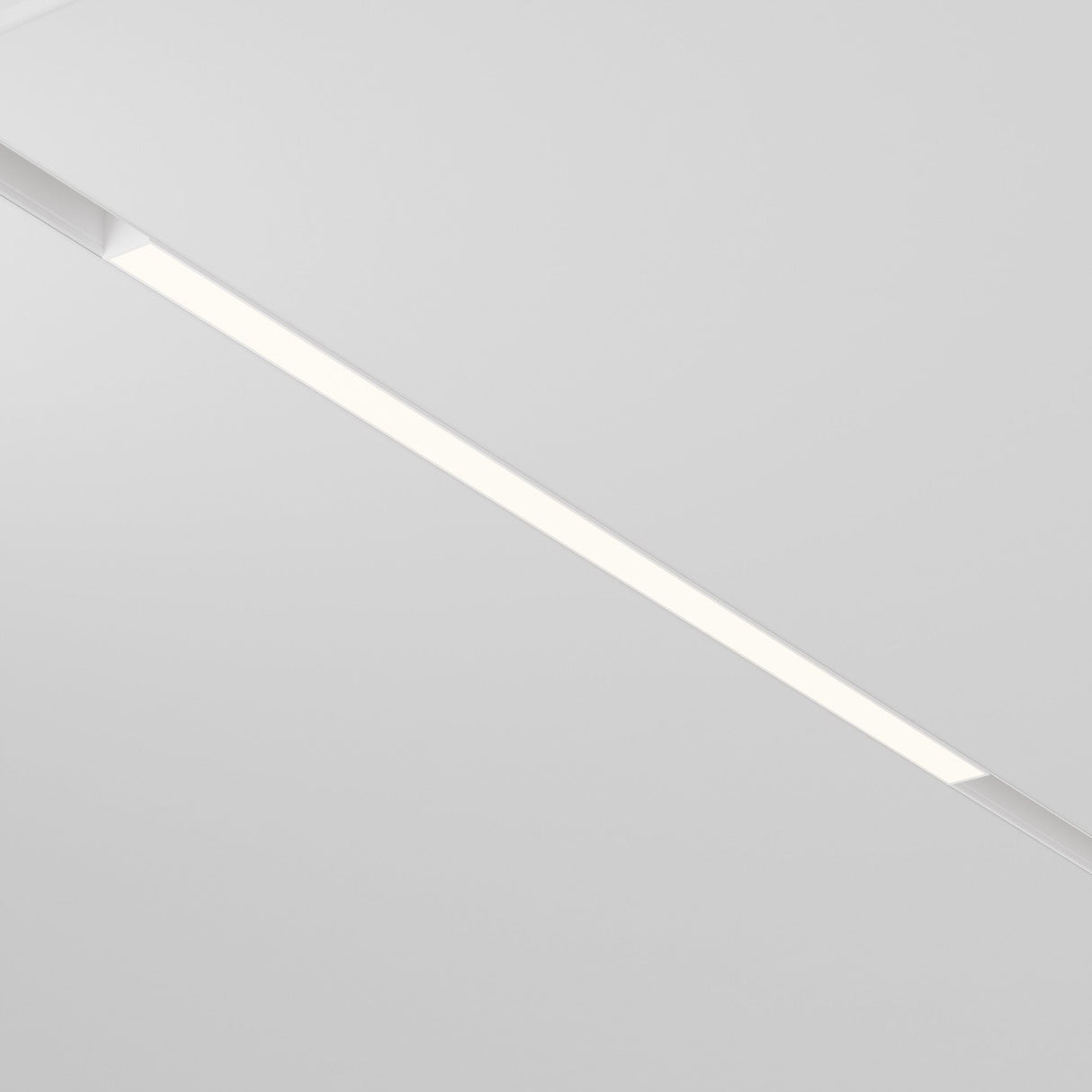 A modern ceiling incorporates the Basis LED Linear Light for Magnetic Track Exility 24W 3000K - White, offering a warm ambient glow embedded in a white surface, delivering a clean and minimalist look to the space.