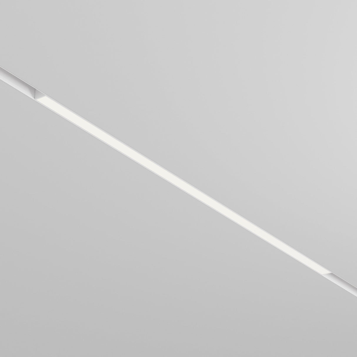 The Basis DALI CCT LED Dimmable Linear Track Light, a thin 30W strip offering 2700-6000K customizable lighting, is embedded in a white ceiling. Its minimalistic design creates a modern aesthetic and allows mood-enhancing lighting adjustments.