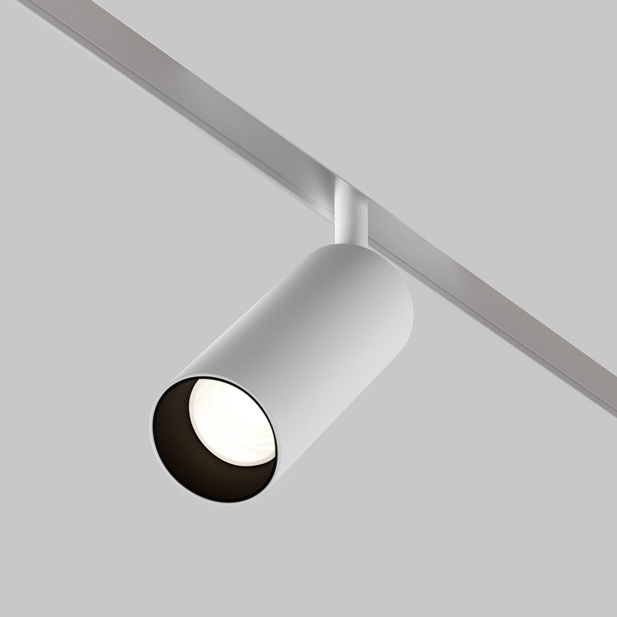 The Focus LED Magnetic Exility Track Spotlight 12W 4000K - White is mounted on a horizontal rail against a simple gray background, featuring sleek, cylindrical white housing. It emits natural white light with a high color rendering index through its circular opening, casting a bright glow.