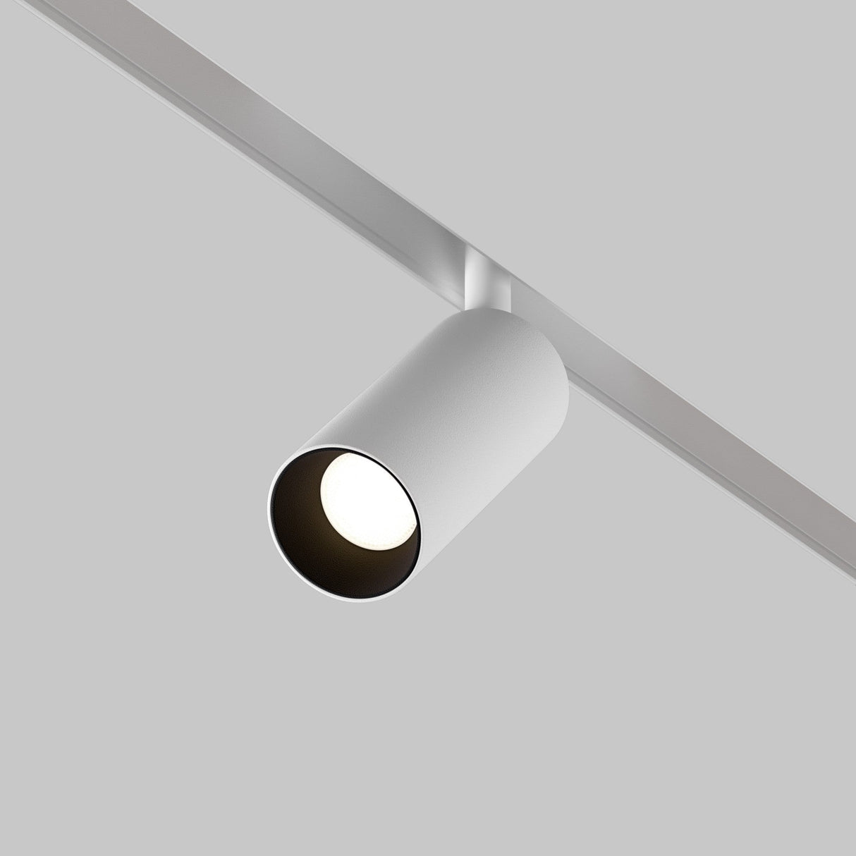 A white Focus LED Magnetic Exility Track Spotlight 5W 4000K is mounted on a gray track against a light gray ceiling, casting a soft glow that embodies minimalist and modern design.