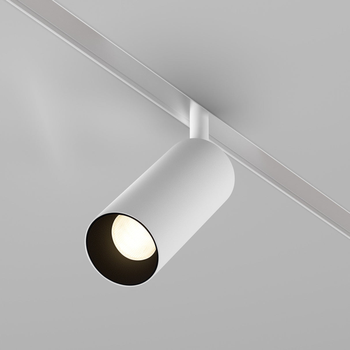 The Focus LED CCT Magnetic Exility Track Spotlight 12W 2700-6000K in white is mounted on a ceiling rail, casting a focused glow. Its modern design and smart control with adjustable color temperature enhance ambiance and highlight spaces beautifully.