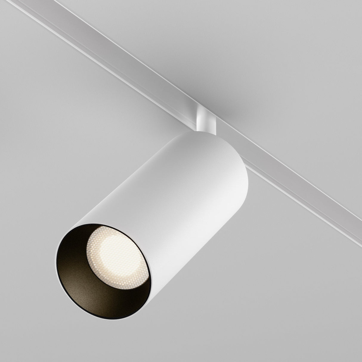 The Focus LED DALI CCT Magnetic Exility Track Spotlight 20W 2700-6000K - White is a minimalist cylindrical ceiling light fixture with magnetic installation, mounted on a linear track against a plain grey ceiling.