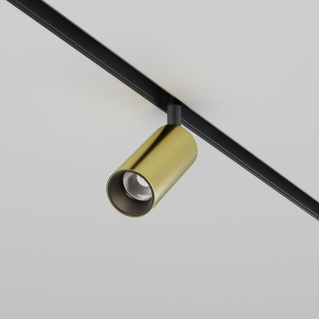 The Focus LED CCT Magnetic Exility Track Spotlight 5W in Black & Brass, with a modern cylindrical design, is installed on a black rail across a white ceiling, offering sleek and minimalist magnetic lighting that beautifully contrasts with the simplicity of the ceiling.