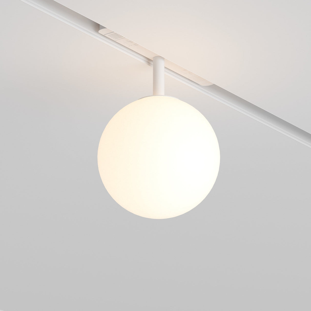 The Luna LED Magnetic Exility Track Globe Ceiling Light (5W, 3000K, White) emits a soft, warm glow and is mounted on an LED magnetic track on a smooth white ceiling, offering a minimalist and contemporary ambiance ideal for modern interiors.