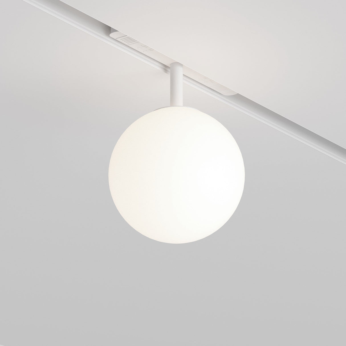 The Luna CCT LED Dimmable Smart Magnetic Exility Track Globe Ceiling Light features a sleek white orb perfect for any setting, offering adjustable 3000-6000K color temperature against a light gray backdrop for the ideal ambiance.