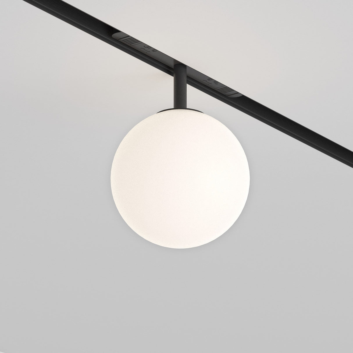 The Luna CCT LED Black Globe Ceiling Light is a minimalist fixture with a spherical white globe, energy-efficient 6W LEDs, dimmable DALI magnetic technology, and an adjustable color temperature of 2700-6000K, suspended from a slender black rod against a plain white ceiling.