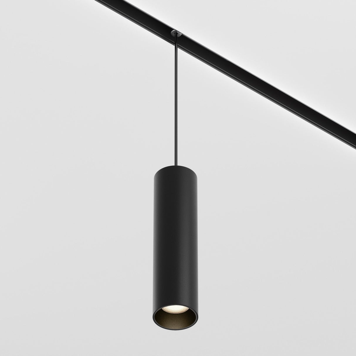 The Focus LED Exility Magnetic Track Pendant Light 12W 3000K - Black hangs elegantly from a magnetic track on the ceiling rail, delivering modern industrial lighting against a plain white background.