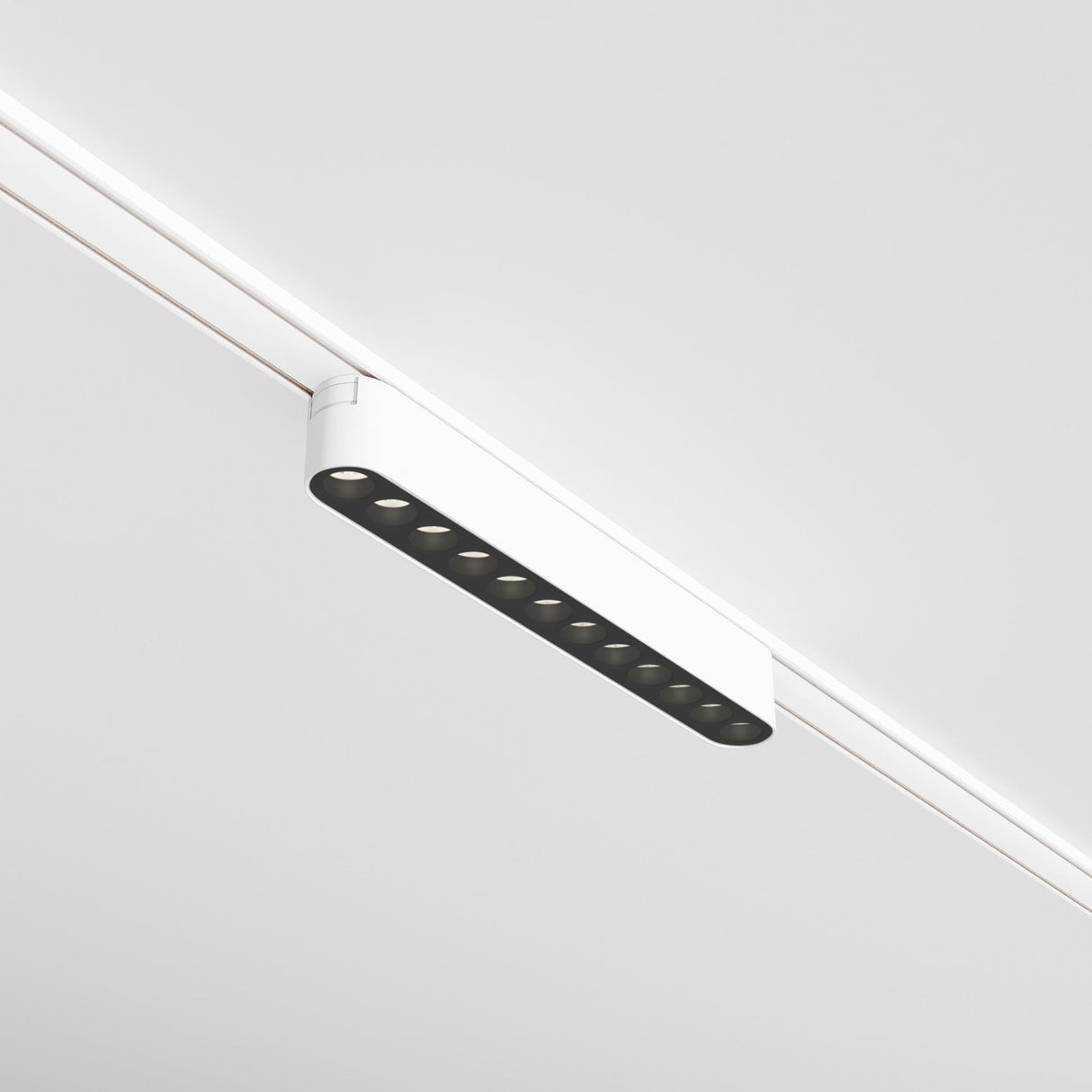 The Points LED Linear Track Light for Magnetic Tracks Radity features eight black bulbs within a sleek white casing on a plain ceiling, emitting 4000K neutral white light. Its smooth lines and contemporary design create a minimalistic modern aesthetic.