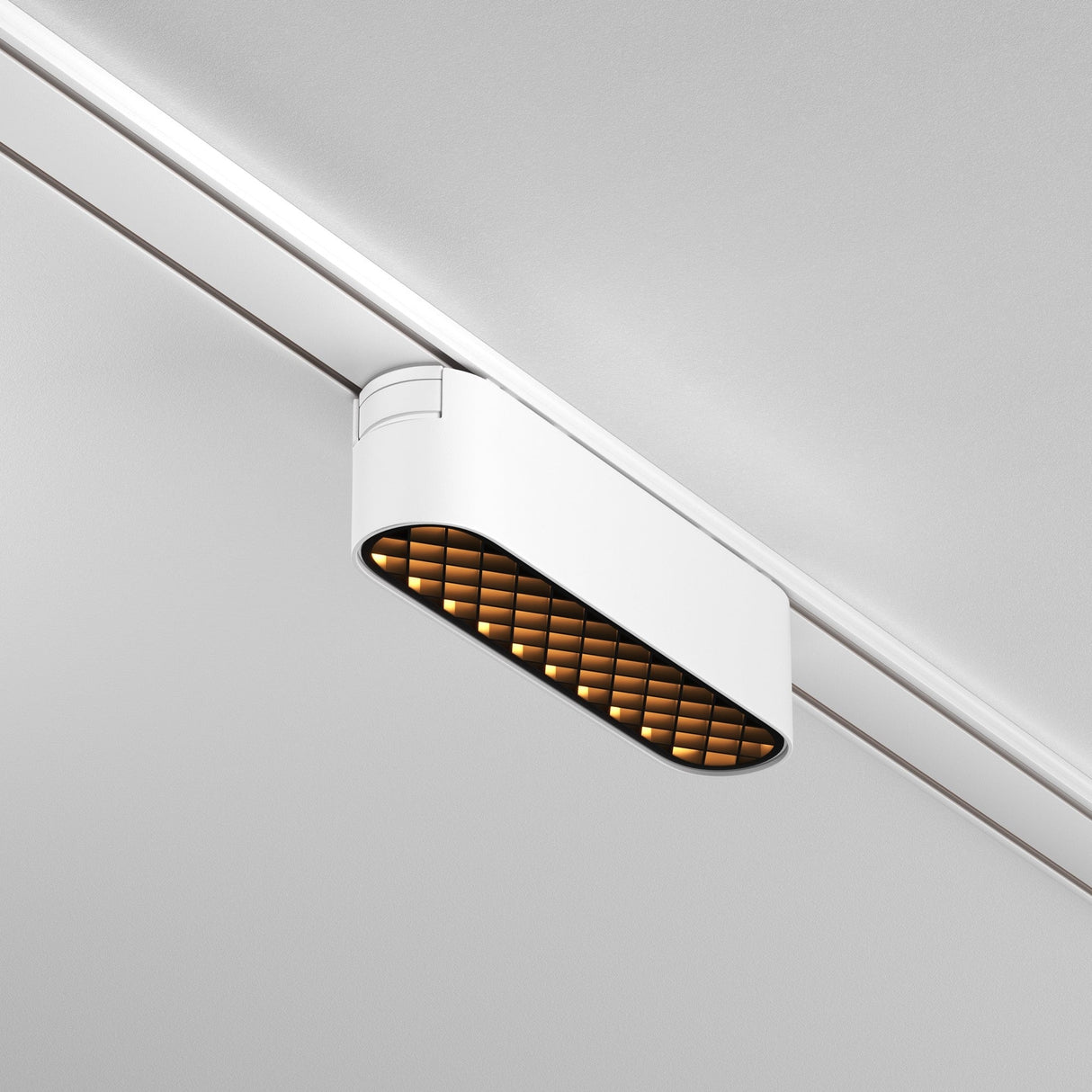 The Basis Grid LED Linear Track Light for Magnetic Tracks Radity 6W 3000K in white features a modern design with a grid diffuser, mounted on a ceiling track. Its adjustable lighting emits a warm glow, creating a striking contrast against the minimalist white ceiling.