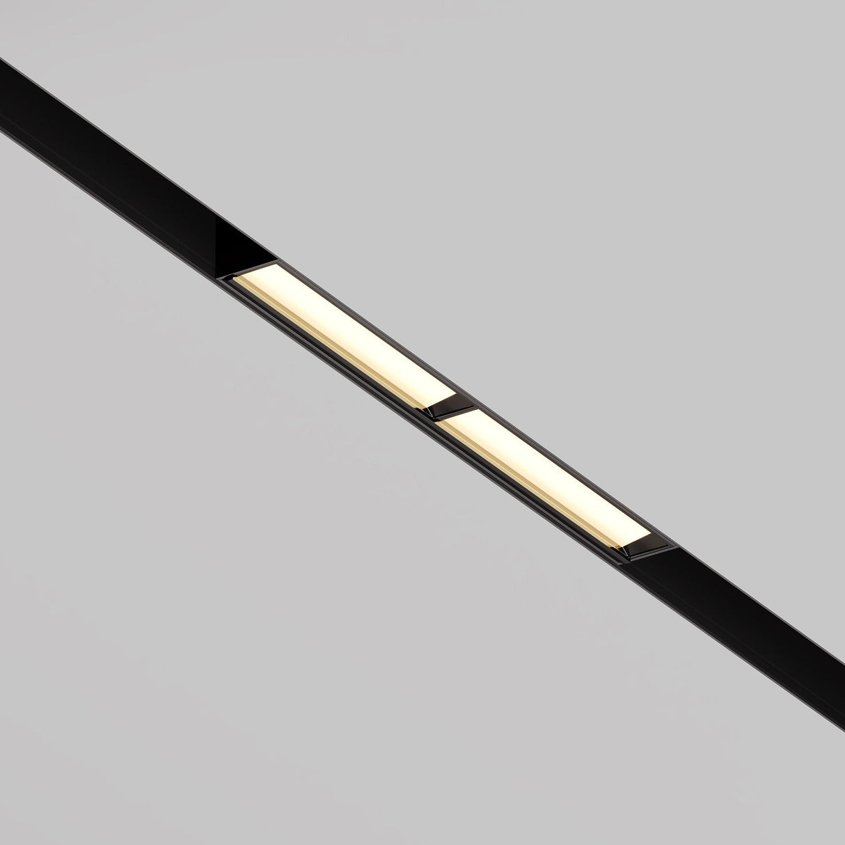 The Parete LED Linear Track Light for Magnetic Exility 12W 3000K - Black, with its minimalist frame, is mounted against a grey ceiling. This sleek fixture emits a soft, warm glow and offers impressive energy efficiency for modern spaces.