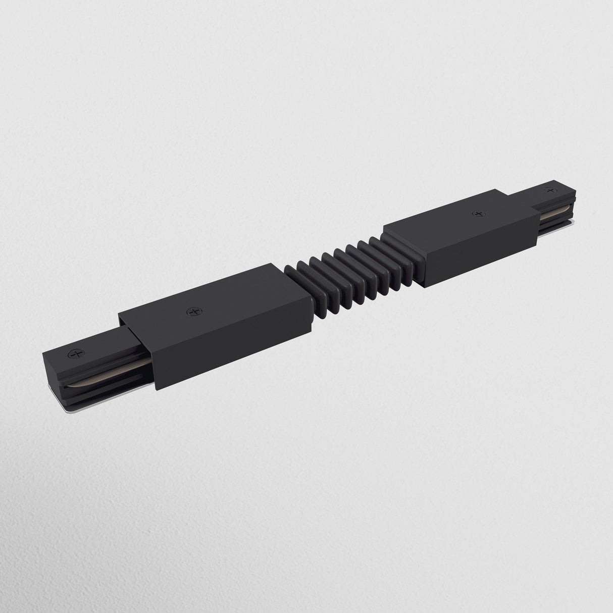 The Unity Single Phase Surface-Mounted Track Flexible Connector in black features a sleek, modern design with an accordion-style segment and rectangular ends. It seamlessly integrates into track lighting for versatile positioning and offers striking contrast against a white background.