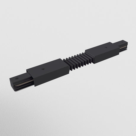 The Unity Single Phase Surface-Mounted Track Flexible Connector in black features a sleek, modern design with an accordion-style segment and rectangular ends. It seamlessly integrates into track lighting for versatile positioning and offers striking contrast against a white background.