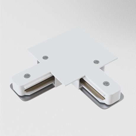 The Unity Tracks Recessed L-Shaped Connector in white, featuring two exposed metal contacts and four screws, sits seamlessly on a light gray surface, ideal for minimalist interiors.