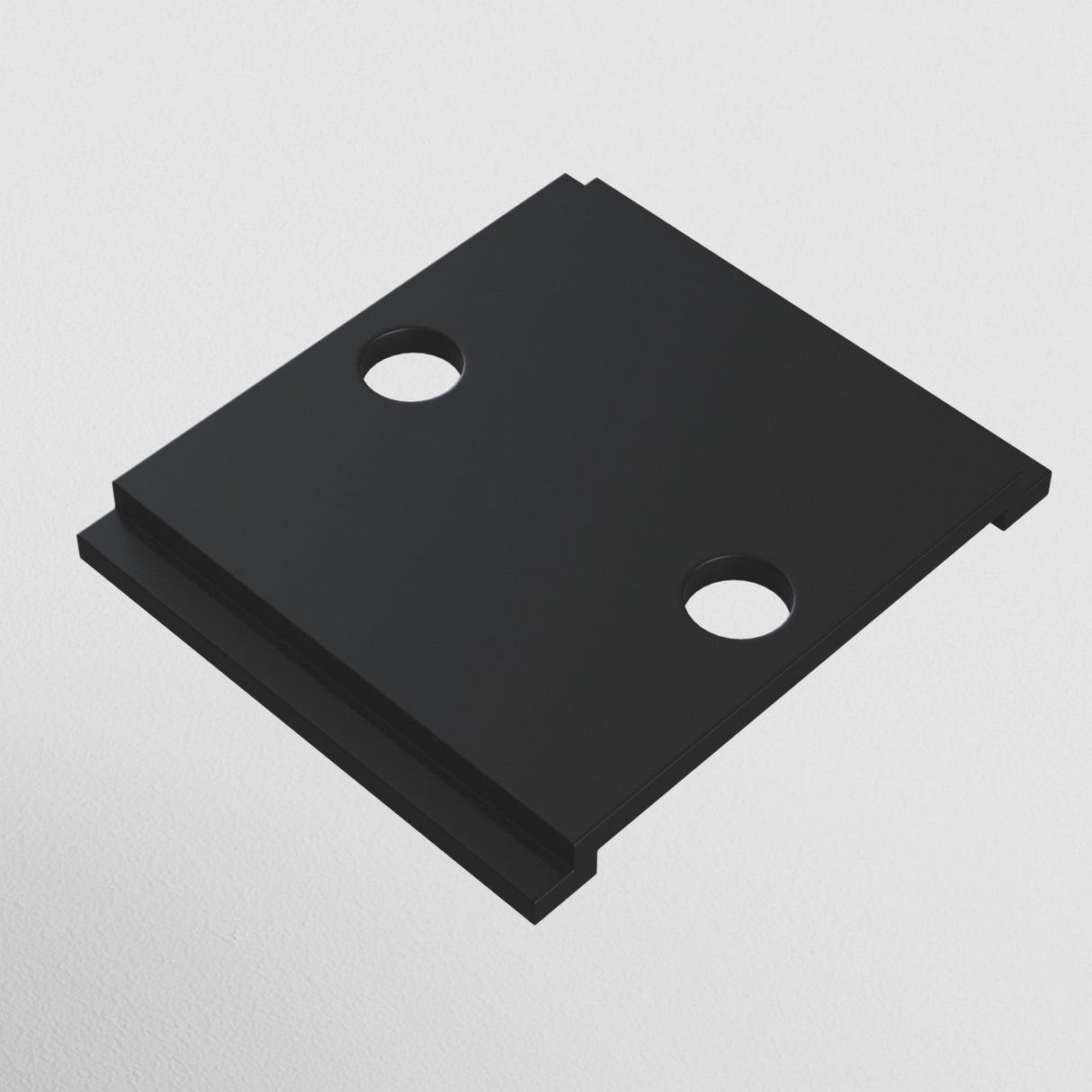 The S35 Magnetic Track Cable Mount - Black is a rectangular metal plate with two central symmetrical circular holes, designed for the S35 track system. Photographed on a plain white background, it showcases an innovative cable management solution.