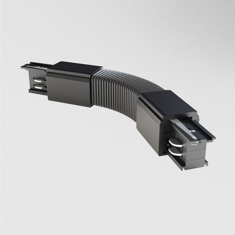 The black 3-Phase Surface-Mounted Track Trinity Flexible Connector, with its ribbed joint, is perfect for modern interiors. It enhances three-phase track lighting and stands out against white backgrounds.