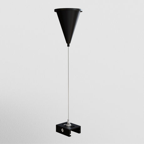 The 3-Phase Surface-Mounted Track Trinity Suspension Cable - Black is mounted on a light gray wall, featuring a funnel-shaped design with a sleek black finish, thin rod, and rectangular base. It also includes a long, adjustable cable to add elegance to any room.