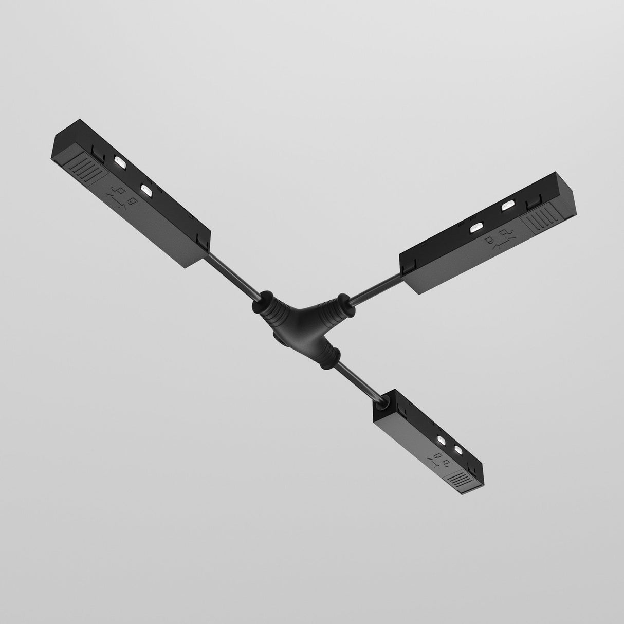 The Exility Tracks Magnetic T-Connector Power Feed in black, featuring rectangular casings, serves as a central junction for the Magnetic Track System, displayed on a plain white background.