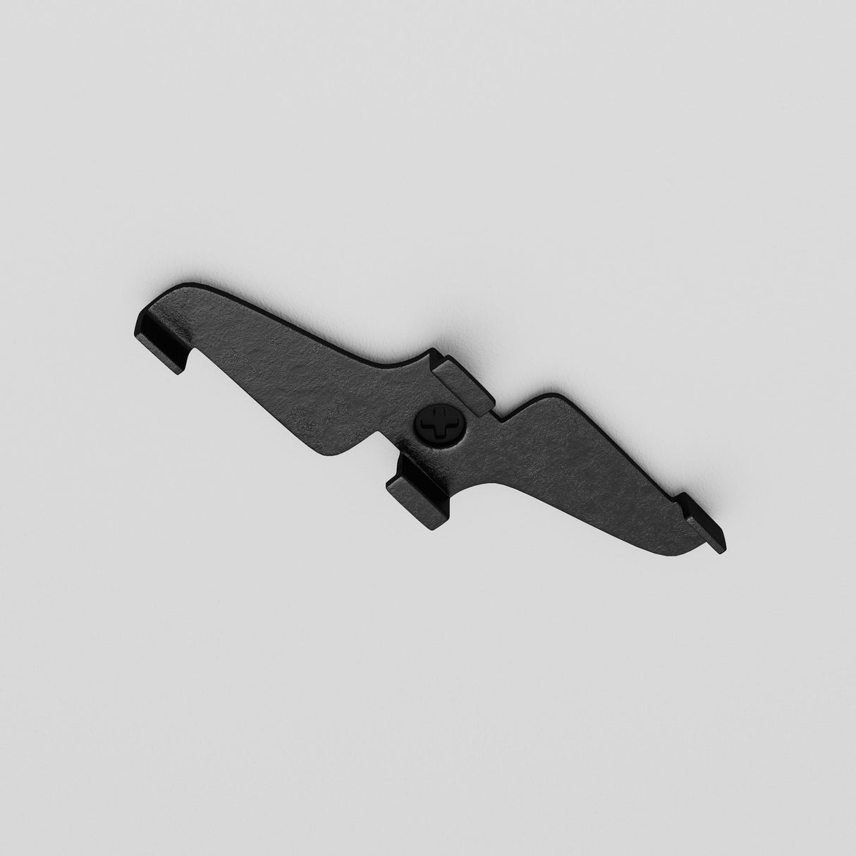 The Exility Magnetic Track Clamp - Black, resembling a bat shape with a central screw hole and two side clips, is set against a light gray background.