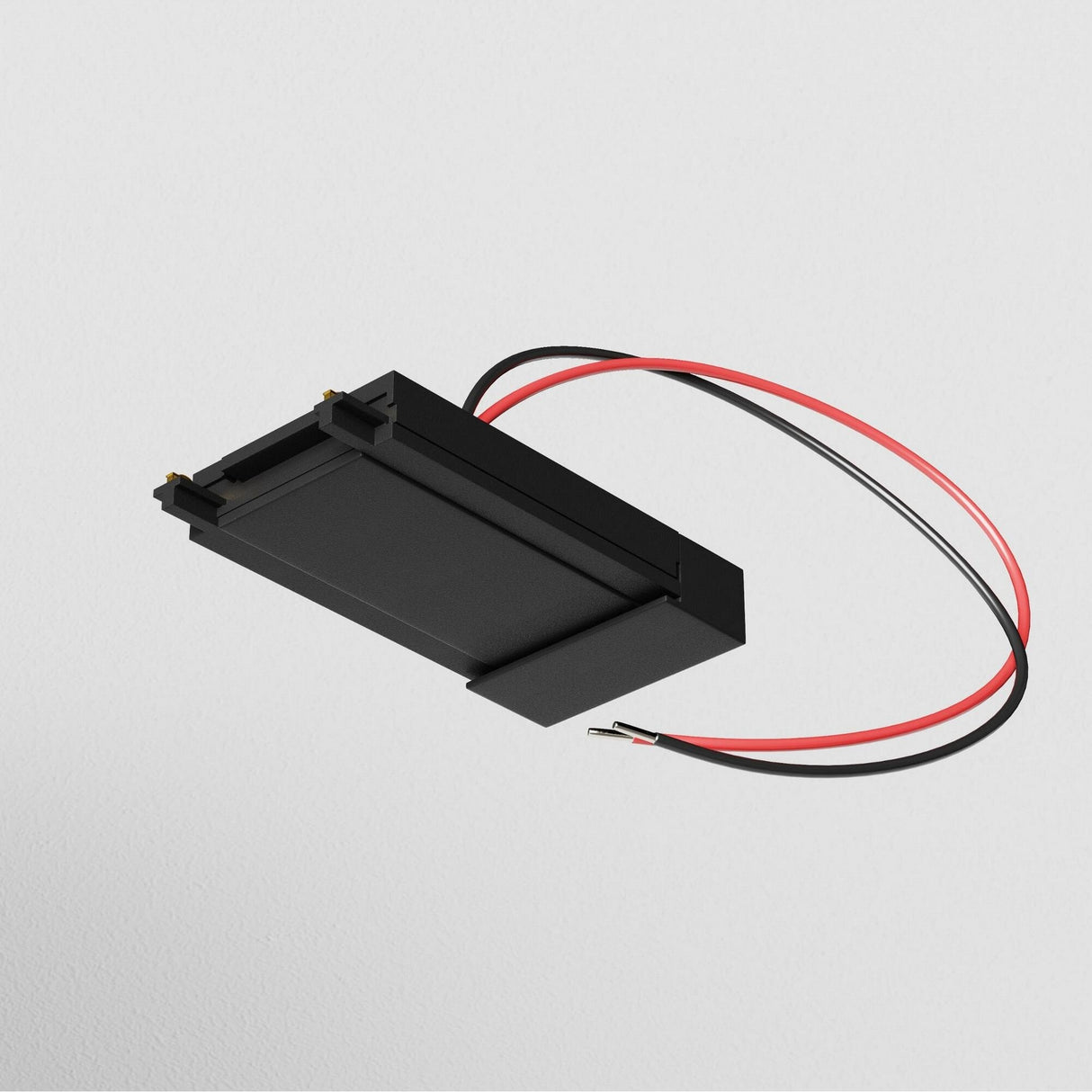The Radity Magnetic Track Surface Power Feed in black features red and black wires for a compact power connection, set against a light gray background.