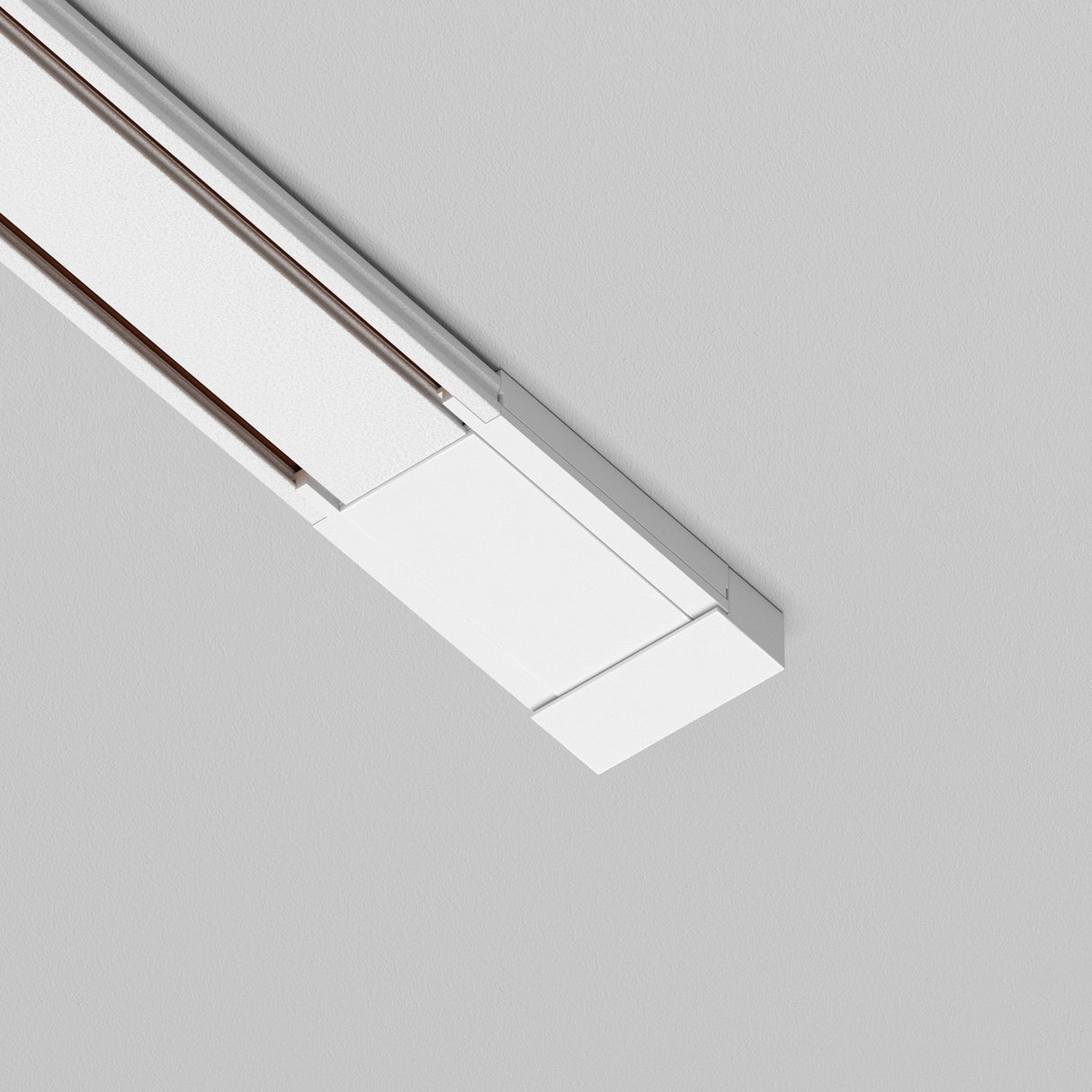 The Radity Magnetic Track Surface Power Feed - White is a modern rectangular ceiling light that features clean lines and a minimalist design, offering a contemporary flair ideal for enhancing modern interiors on a gray ceiling.