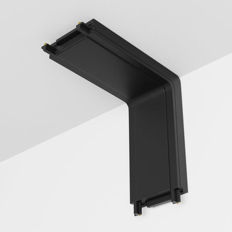 The Radity Magnetic Track Power Connector Internal in black, with a right-angle wall-mounted design, seamlessly integrates into a white ceiling, enhancing your magnetic track lighting system.